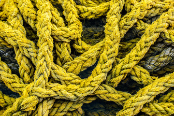 Fototapeta na wymiar Old yellow boat rope background. Strong vintage rope for mooring the ship at the berth.