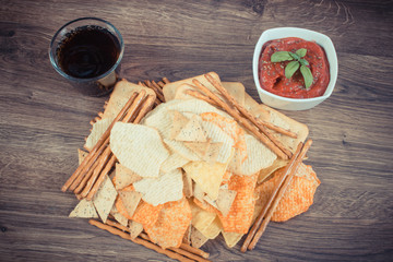 Vintage photo, Heap of unhealthy food, sauce with basil and cola on wooden board