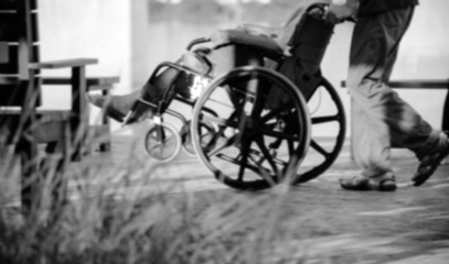 Fototapeta na wymiar Elderly old woman on wheelchair black and white blur.