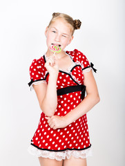 Portrait of happy beautiful young girl with sweet candys. pretty young woman dressed in a red dress with white polka dots holding two colorful lollipop