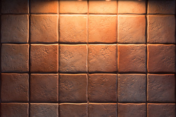 Texture of fine ceramic tiles for kitchen wall illuminated from above. Close up tiled background.
