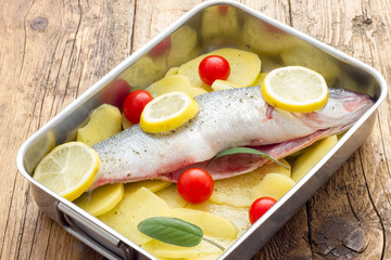 Fish with lemon potatoes and tomatoes ready for the oven