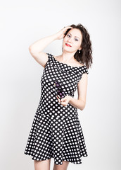 Beautiful young woman removes sun glasses, wears a dress with polka dots. expressing different emotions