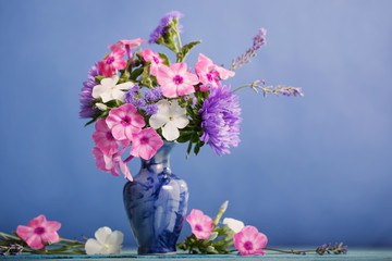 flowers in a vase on blue  background