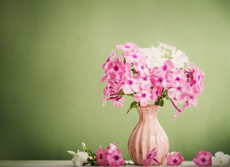 flowers in a vase on green background