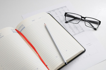 Work table in office businessman. Notebook with the pen and glass on table
