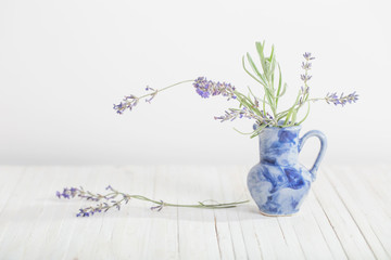 Fresh lavender in blue jug on white table
