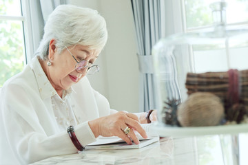 Senior woman reading a book at home