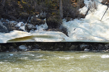 Glacier on the shore of Irkut River in its beginning in the Sayan Mountains in June