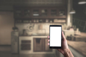 Close up of a man using smart phone with blank mobile and kitche