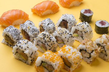 Different Sushi rolls,wasabi and ginger on a plate on wooden bac