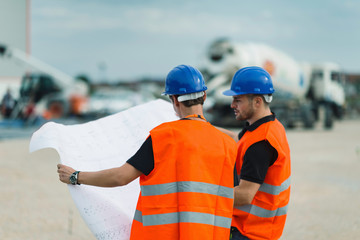 Construction workers with building plans