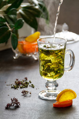 Cup of fresh herbal tea on wooden table. The frozen movement. Selective focus