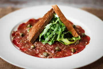 Meat carpaccio of beef on wood table