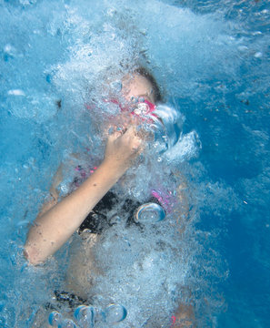 Young girl jumps and having fun in water. 