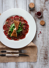Meat carpaccio of beef on wood table