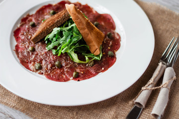 Meat carpaccio of beef on wood table