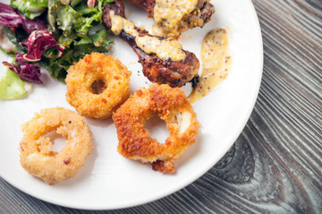 Crunchy fried Onion Rings with salad and roast chicken