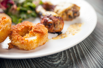 Crunchy fried Onion Rings with salad and roast chicken