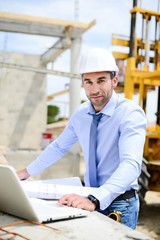 portrait of handsome young man architect on a building industry construction site