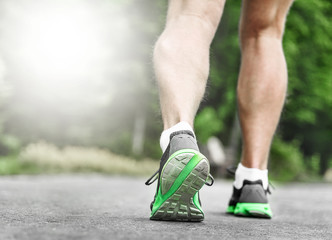 Athlete runner feet running on road.