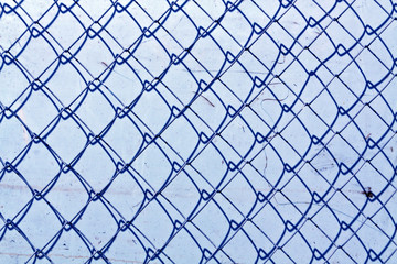 Fototapeta premium abstract chain link fence texture against grungy color wall.