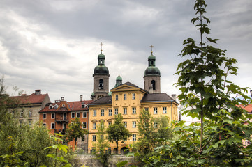Facades of houses in the typical Austrian building style in Innsbruck, Austria with the cathedral in the background
