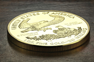 1 ounce American gold eagle bullion coin on wooden background