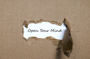 The word open your mind appearing behind torn paper