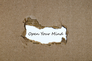 The word open your mind appearing behind torn paper