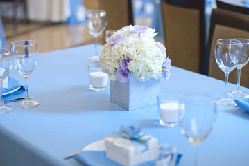Beautiful flowers, candles and bonbonniere on table in wedding day.Blue color decoration tablecloth 