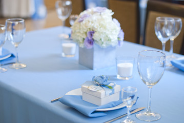 Beautiful flowers, candles and bonbonniere on table in wedding day.Blue color decoration tablecloth 