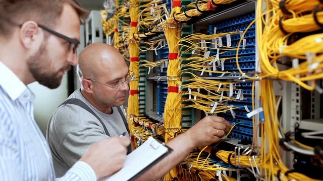 Engineers working in data room. Slow motion.