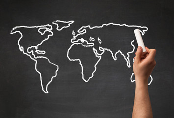 Adult drawing world map on chalkboard