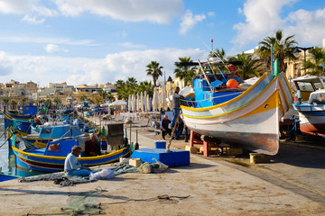 Fototapeta na wymiar Luzzu famous fishing boats in Marsaxlokk - Malta