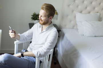 Obraz premium Redhair man with phone in the room