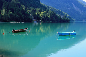 Fototapeta na wymiar Boat on Molveno lake - beautiful morning 