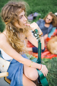 Young beautiful hippie curly hair woman with guitar outdoors