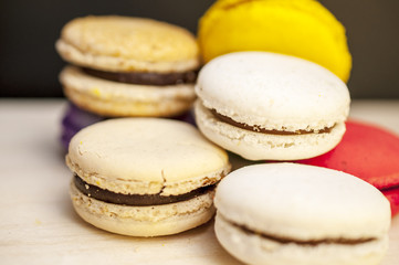 Colorful macaroons on the dark background and wooden table