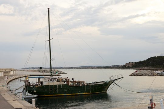 Wooden vintage vessel mooring on the pier in Roc de Sant Gaieta.