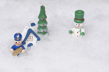 A snowman, house, tree and soldier displayed in artificial snow