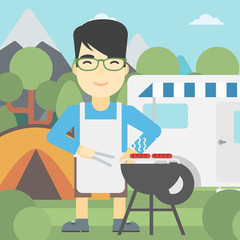 Man having barbecue in front of camper van.