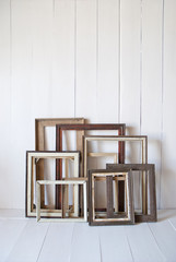 Dirty old vintage picture frames on the wall. White interior room 