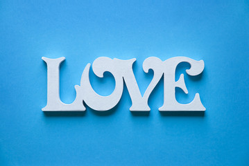 Letters forming word LOVE written on paper blue background 