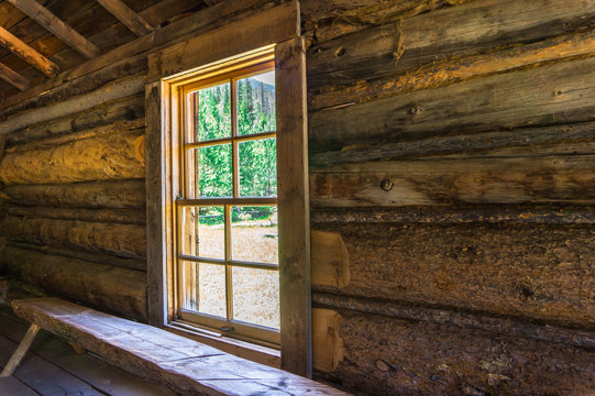 window letting in the sun light in a log cabin
