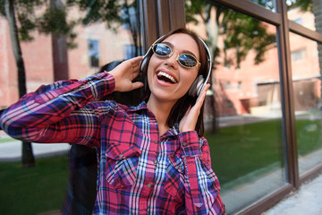 Fototapeta premium Carefree young woman listening song from earphones