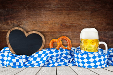 oktoberfest beer pretzel empty heart shaped blackboard in bavarian flag on wooden background /...