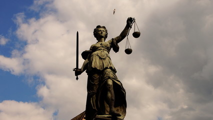 Gerechtigkeitsbrunnen der Justitia am  Frankfurter  Römerberg vor lebhaftem Himmel