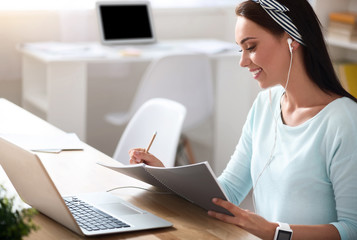 Pleasant delighted woman making notes