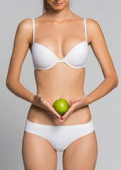 Beautiful woman body and green apple. Conceptual image of dieting healthy lifestyle
